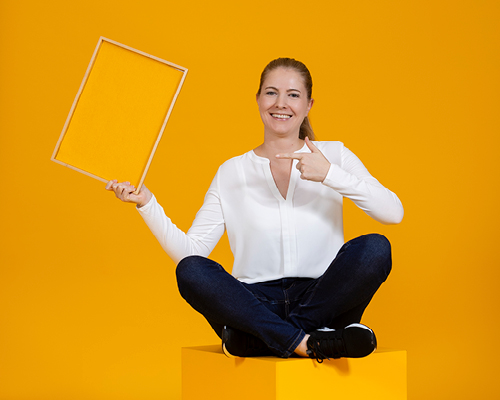 Employee spreading the LOGICspirit and pointing to an orange sign